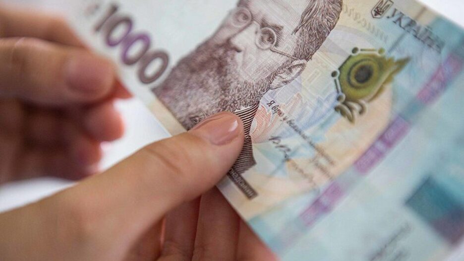 1000 гривень у руках